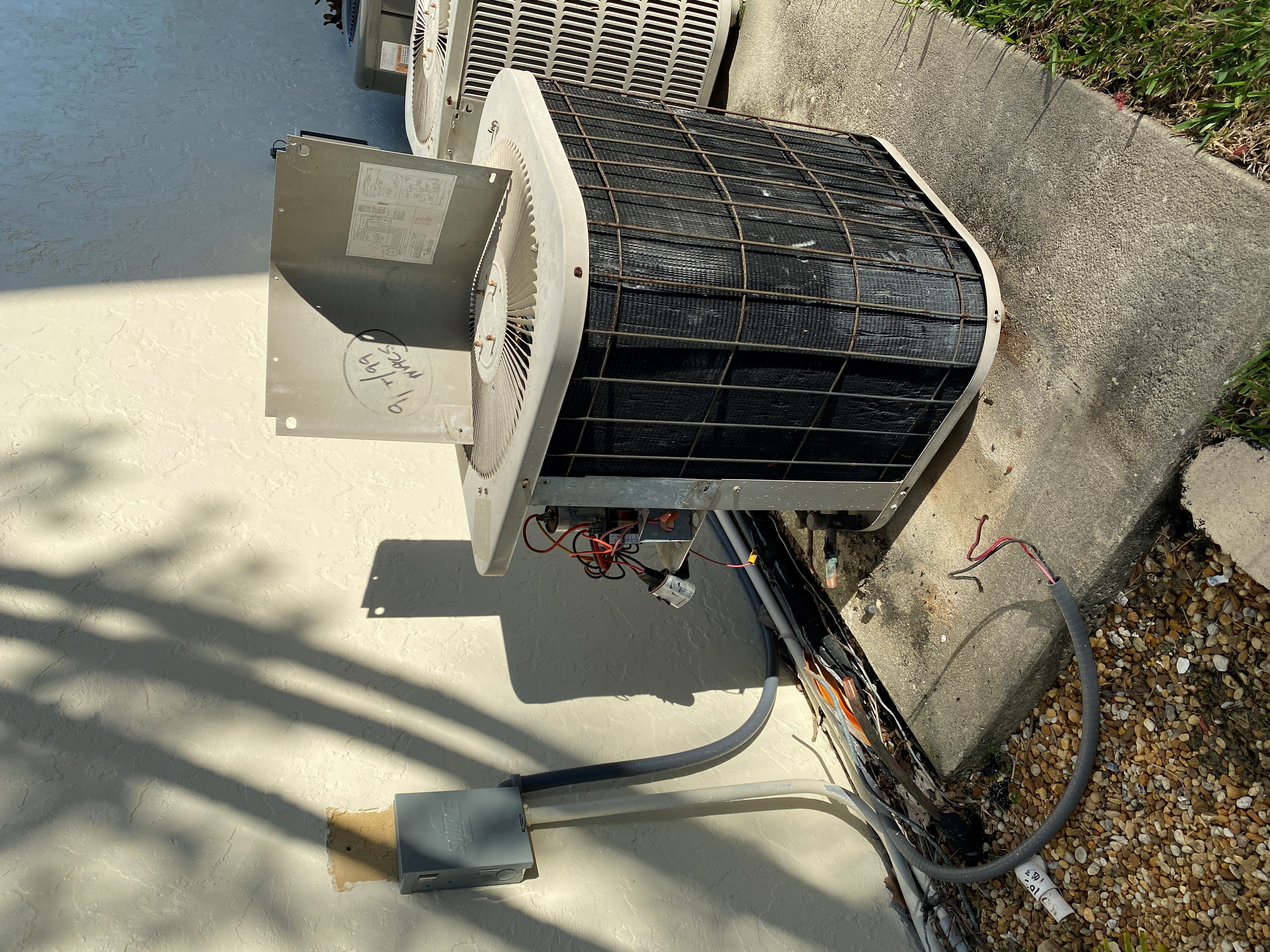 Old corroded outdoor AC condenser showing salt air damage in Southwest Florida