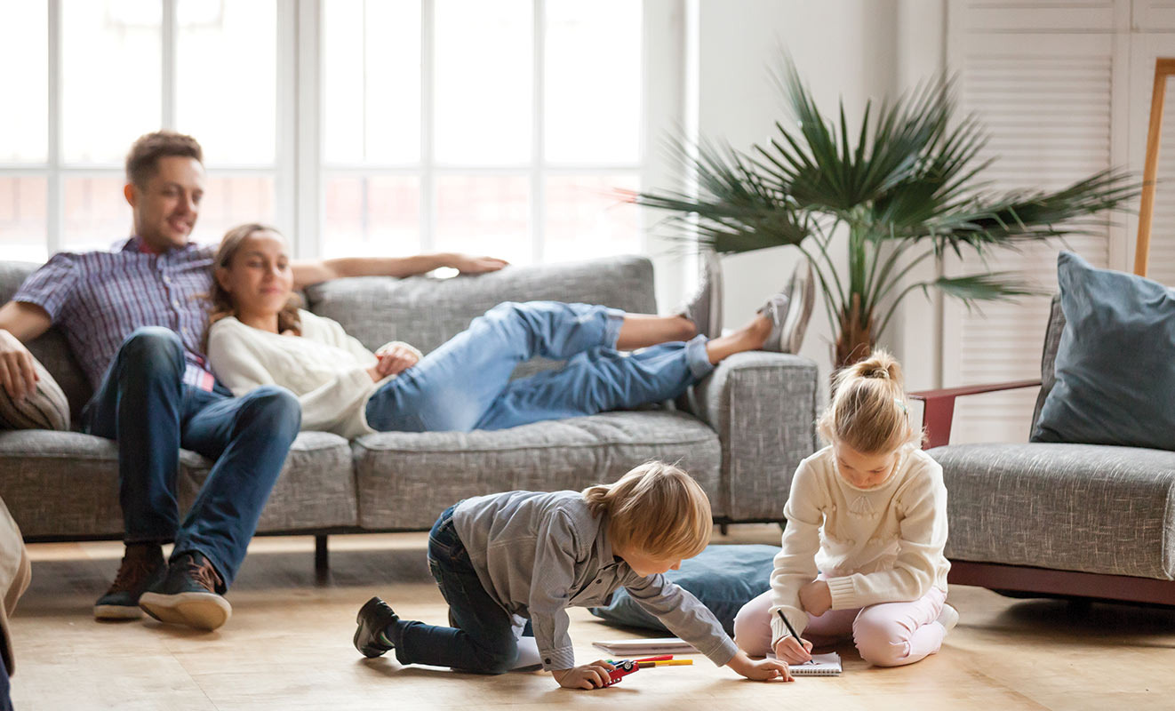 Happy family relaxing comfortably at home with a working AC in Southwest Florida