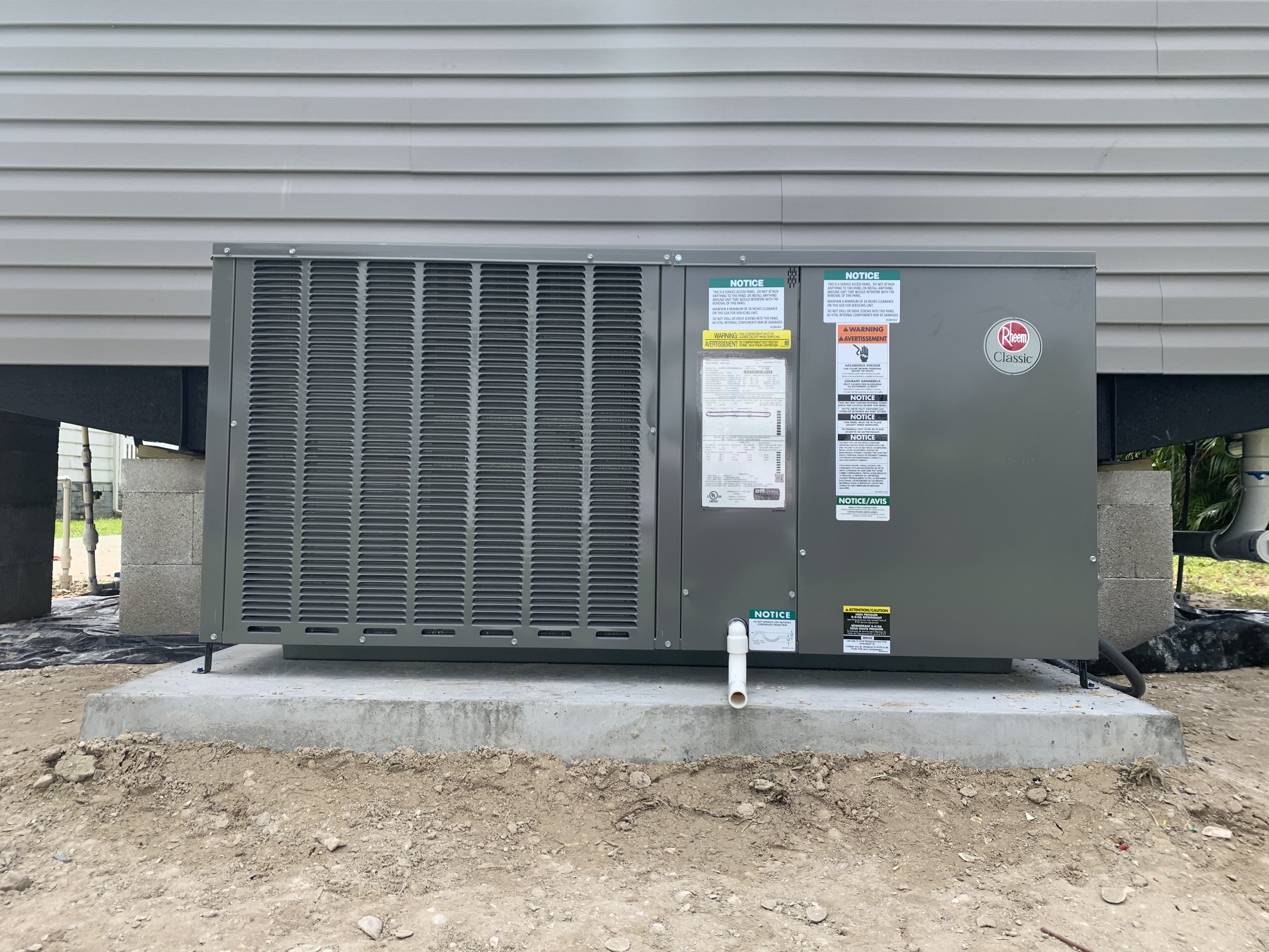 New Rheem package unit installed on a fresh concrete pad by HomePros Cooling and Heating Fort Myers