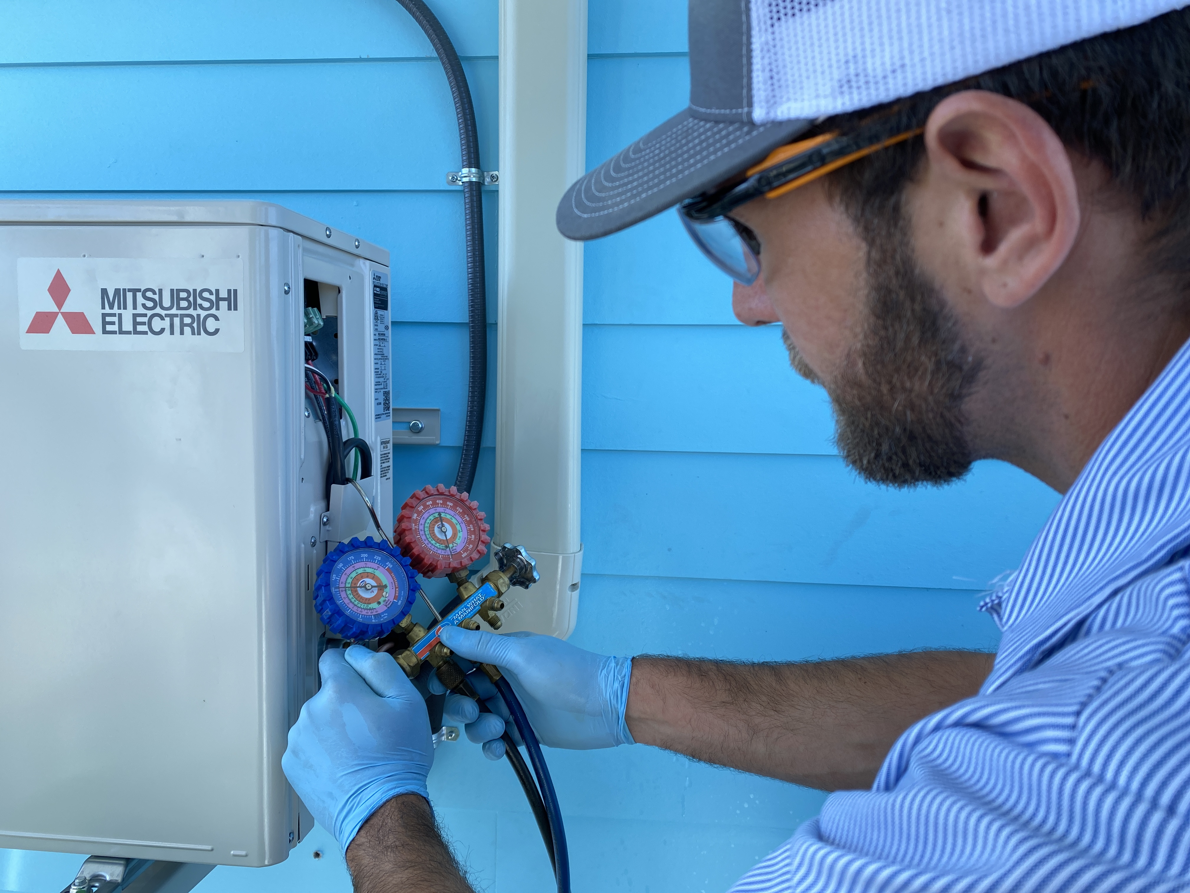 HomePros technician checking refrigerant levels on an AC system in Southwest Florida