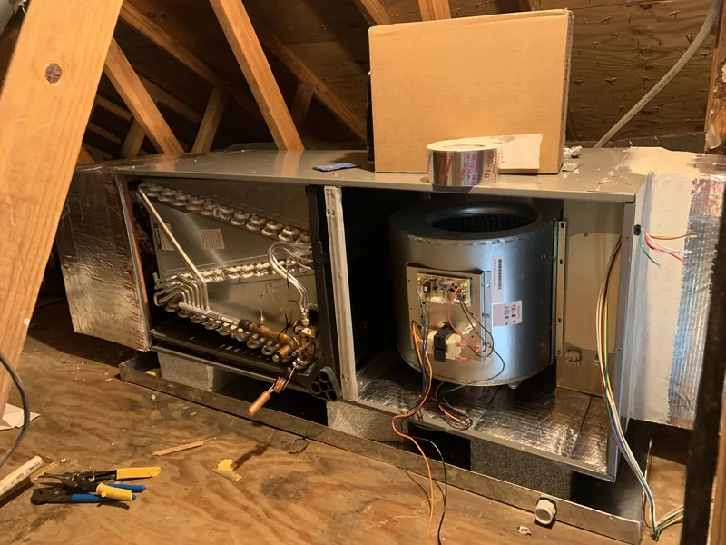 HomePros Cooling & Heating technicians installing an attic air handler system in Southwest Florida